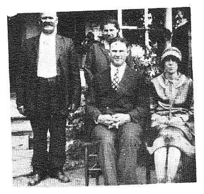 Group photo of five people, two standing men behind, a seated man and woman in front, and another woman standing beside them