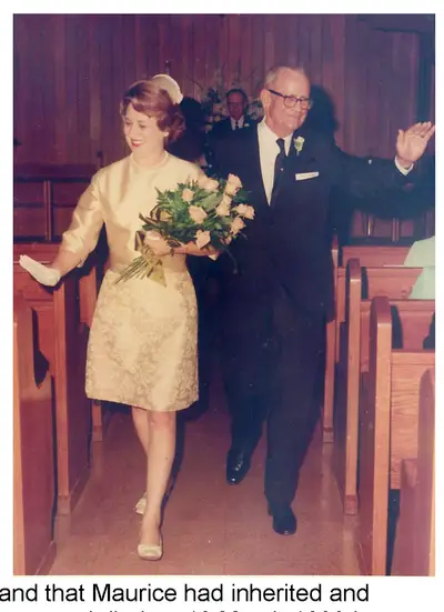 Wedding photo of a bride in a gold dress holding a bouquet of white roses walking down the church aisle on the arm of an older groom in a dark suit, who is waving to the congregation.