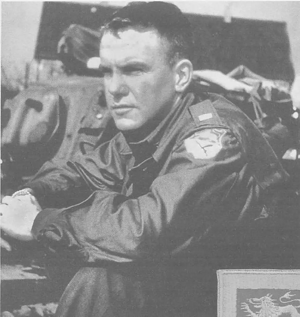 Black and white photograph of a soldier, Charlie A. Kearns, seated on a vehicle wearing an M43 jacket with the 15th Cavalry patch visible on the sleeve.