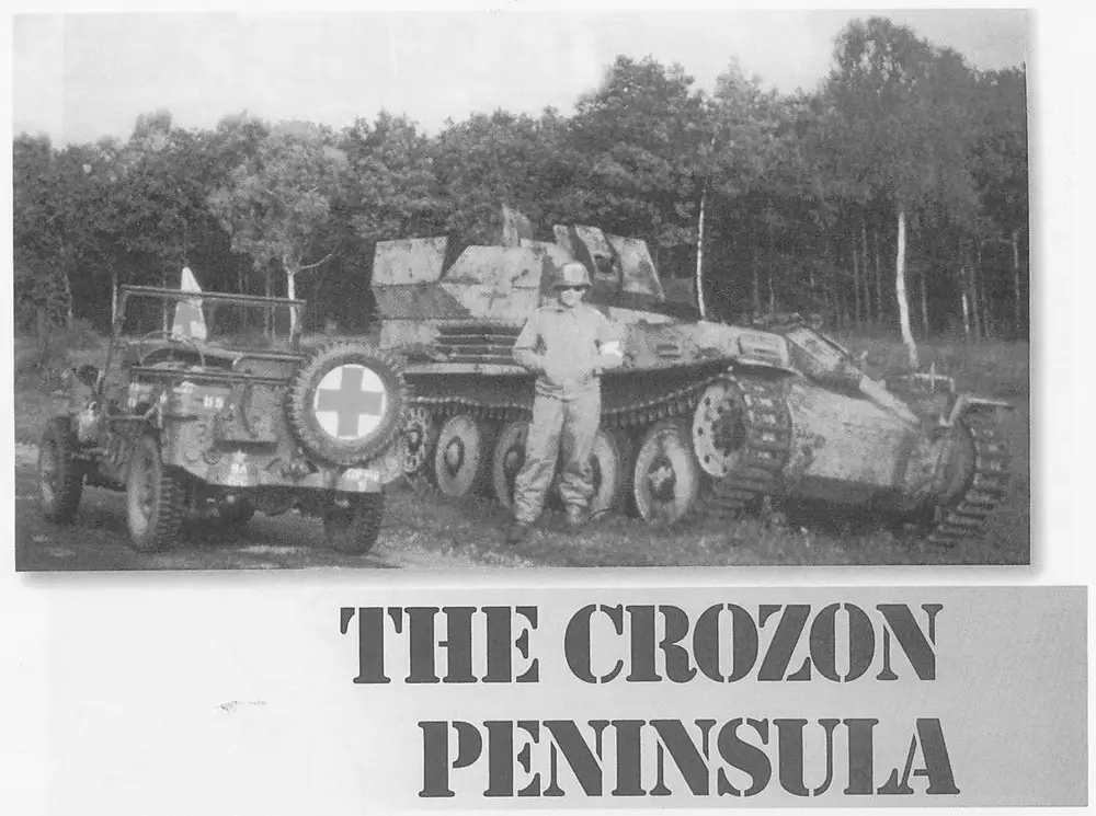 A soldier (identified in the caption as Dr. Bill Parker) standing beside a captured German Flakpanzer 38(t) self-propelled anti-aircraft gun, with a light vehicle/jeep with a large spare tire marked with a cross symbol parked alongside; trees in the background.
