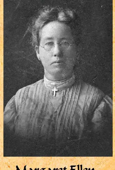 Studio portrait of a woman wearing glasses and a dress with a high collar and cross necklace.